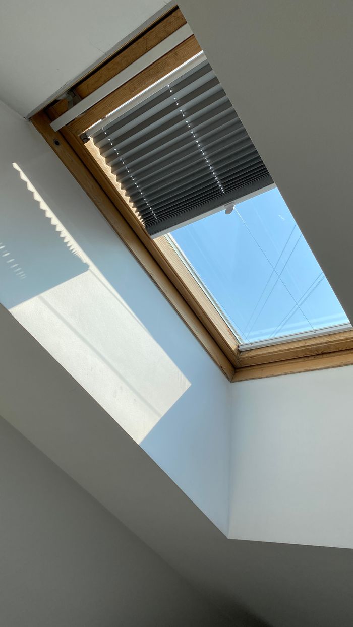 services-01 A ceiling skylight with blinds allows natural light into a minimalist interior. Perfect for architectural and design needs.