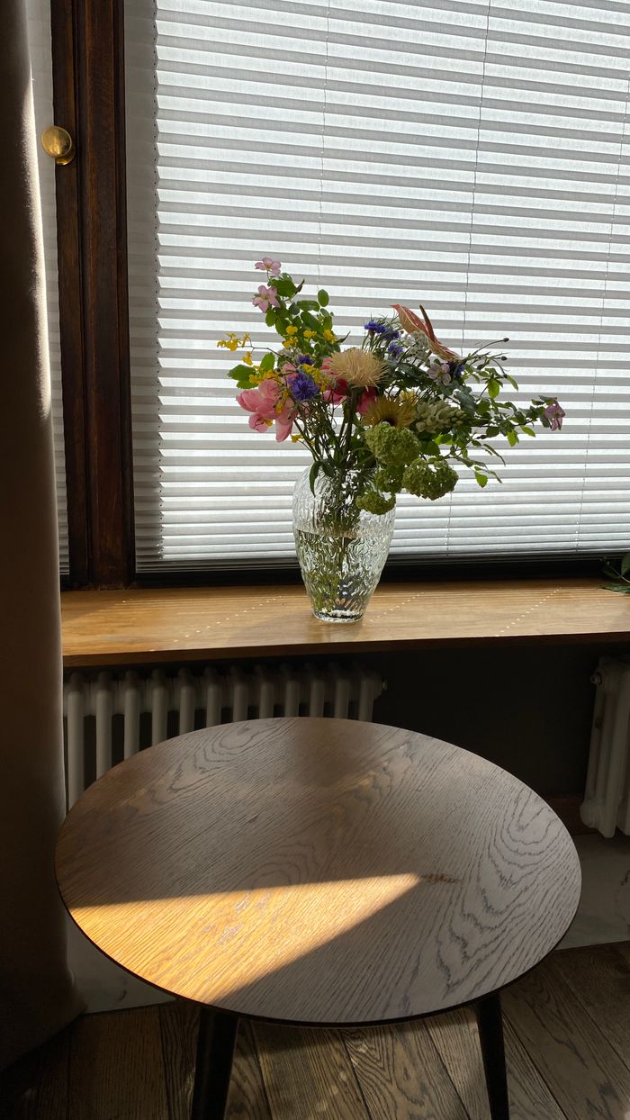 footer-cta-img A vibrant flower arrangement in a vase by a window, indoors with natural light.
