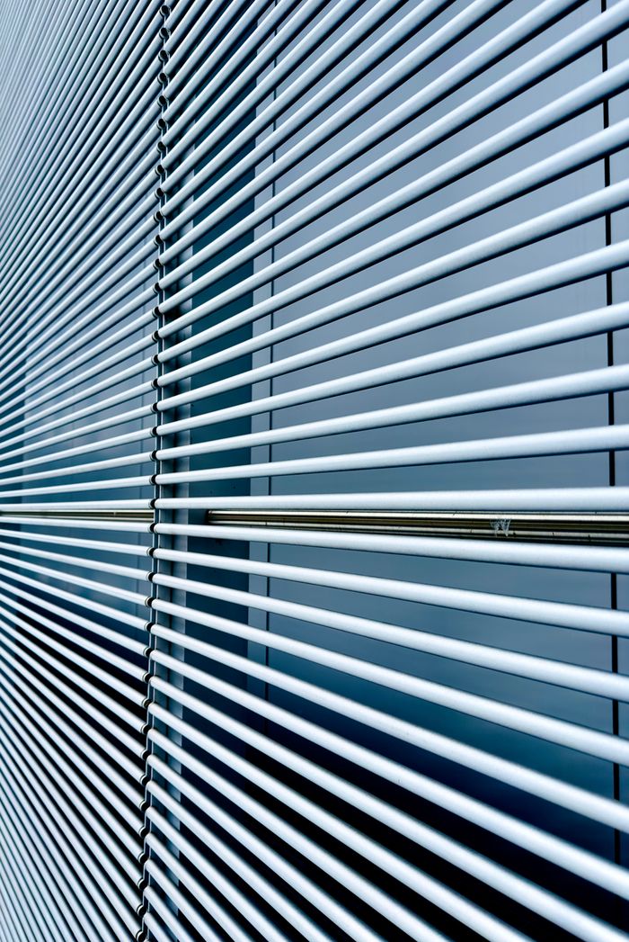 services-01 Abstract image of modern window blinds with straight horizontal lines and cool tones.